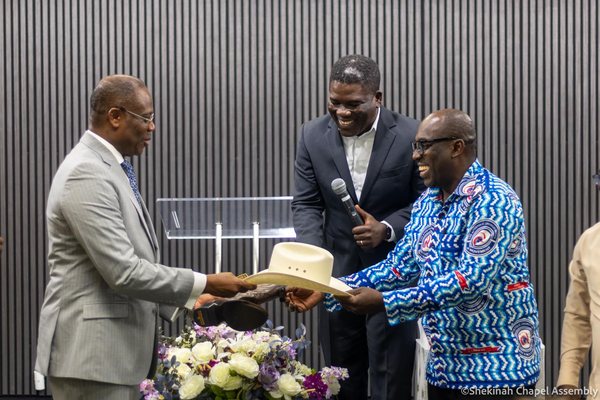 Apostle Dr Aaron Ami-Narh, President of The Apostolic Church, is presented with a Texas hat and boots during a Men's Movement service.